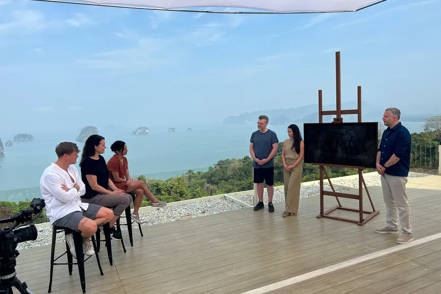 Cast and crew on a clifftop deck overlooking the islands during a shoot.